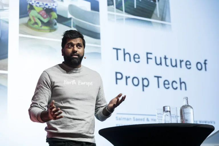 An Image of someone speaking at a seminar about proptech